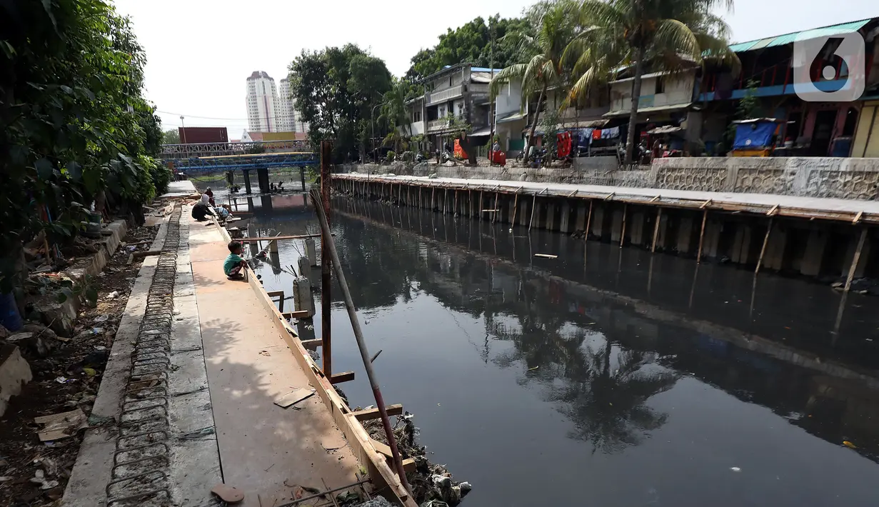 Suasana saat pekerja mengerjakan proyek pembangunan tanggul bantaran Kali Anak Ciliwung di RT 001 RW 008 Ancol, Pademangan, Jakarta Utara, Kamis (19/12/2019). Pembangunan tanggul untuk mencegah amblesnya bantaran sungai seperti pada akhir tahun 2018 lalu. (Liputan6.com/Johan Tallo)