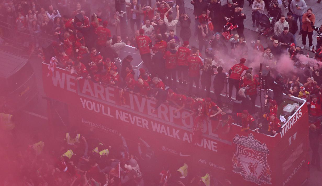 Ribuan fans Liverpool memadati jalan-jalan kota untuk menyambut tim kebanggaan mereka yang melakukan parade di atas bus terbuka pada Minggu (29/05/2022) waktu setempat. Musim ini, The Reds berhasil meraih dua trofi yaitu Piala FA dan Piala Liga Inggris. (AFP/Oli Scarff)