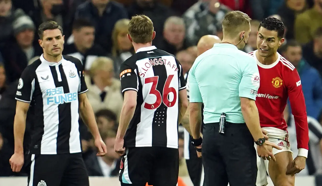 Pemain Manchester United Cristiano Ronaldo (kanan) berdiskusi dengan wasit Craig Pawson saat melawan Newcastle United pada pertandingan sepak bola Liga Inggris di St. James' Park, Newcastle, Inggris, Senin (27/12/2021). Pertandingan berakhir imbang 1-1. (AP Photo/Jon Super)