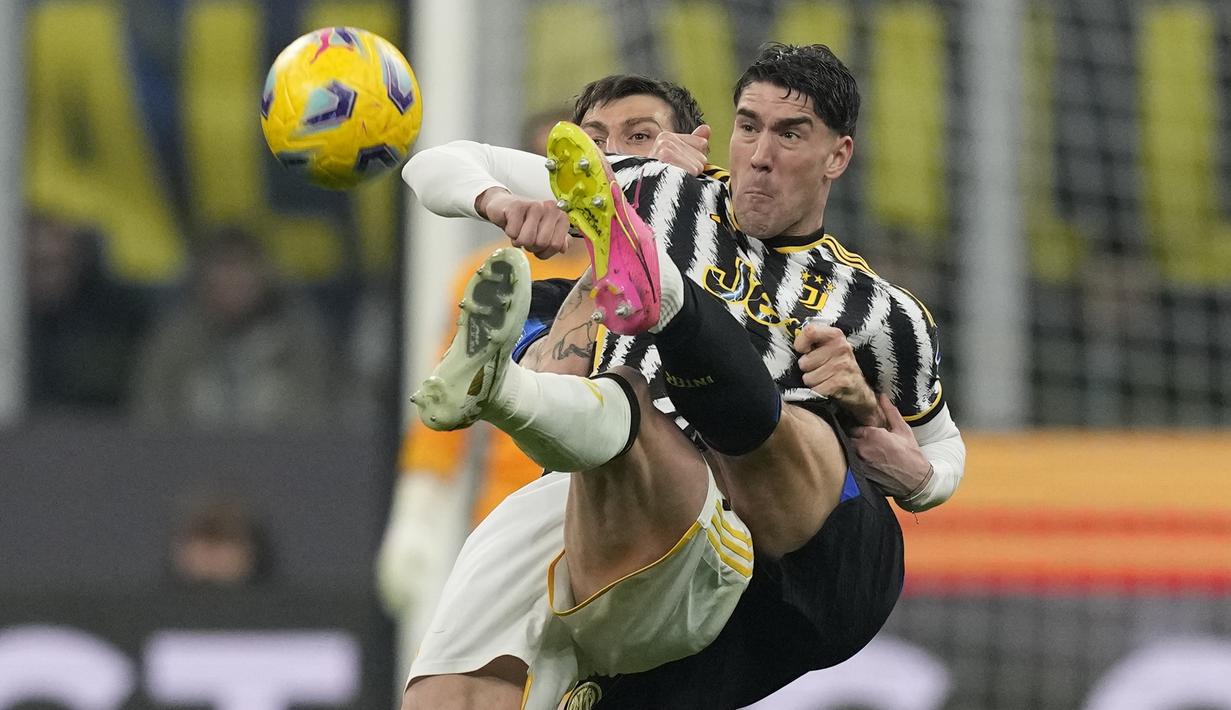 Pemain Inter Milan, Francesco Acerbi, berebut bola dengan pemain Juventus, Dusan Vlahovic, pada laga pekan ke-23 Serie A 2023/2024 di Giuseppe Meazza, Senin (05/02/2024). Sementara itu Juventus ada di posisi kedua dengan mencatatkan 53 angka dari 23 pertandingan. (AP Photo/Antonio Calanni)