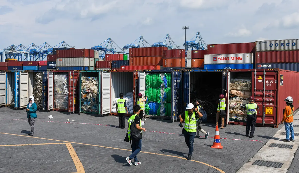 Pejabat dan jurnalis Malaysia memeriksa kontainer berisi limbah plastik sebelum dikirim kembali ke negara asal di Port Klang, sebelah barat Kuala Lumpur, Selasa (28/5/2019). Malaysia mengembalikan limbah plastik yang tidak dapat didaur ulang dari negara-negara maju. (Mohd RASFAN/AFP)