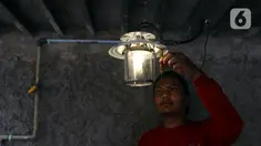 Pekerja menyalakan lampu menggunakan bahan bakar biogas yang mengubah kotoran sapi menjadi gas untuk kebutuhan tumah tangga di kawasan Pancoran, Jakarta, Selasa (12/12/2023). (Liputan6.com/Herman Zakharia)