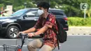 Seorang pria yang mengenakan baju batik bersepeda di kawasan Thamrin Sudirman, Jakarta, Jumat (2/10/2020). Pada Hari Batik Nasional yang berlangsung di tengah pandemi COVID-19, sebagian masyarakat terlihat mengenakan baju dan masker dengan motif batik. (merdeka.com/Imam Buhori)