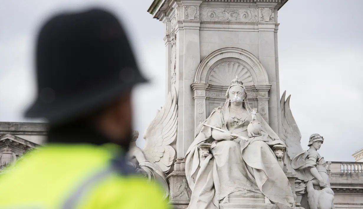 Patung Ratu Inggris Victoria yang berdiri di dekat Istana Buckingham dikenakan masker di London, Inggris, Senin (18/4). Aksi yang dilakukan oleh aktivis lingkungan Greenpeace itu untuk memprotes kualitas polusi udara di kawasan tersebut. (Leon NEAL/AFP)