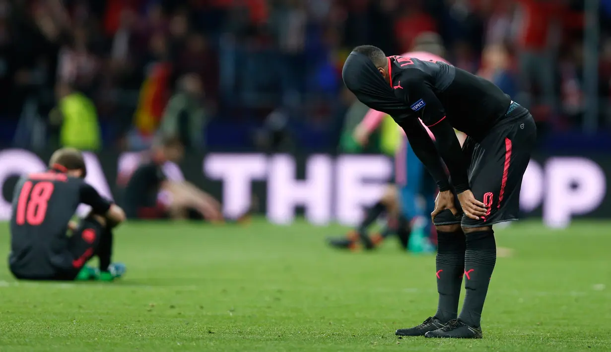 Pemain Arsenal, Alexandre Lacazette menutupi kepalanya dengan jersey usai kalah dari Atletico Madrid pada laga leg kedua semifinal Liga Europa di Wanda Metropolitano, Kamis (3/5). Arsenal tersingkir dari Liga Europa setelah kalah 0-1. (AP/Francisco Seco)