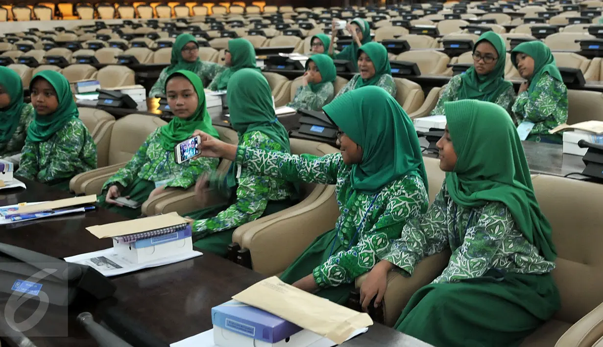 <p>Sejumlah murid SD Al-Azhar Kebayoran Lama berselfie saat melakukan kunjungan ke kompleks Parlemen, Jakarta, Kamis (5/11/2015). Kunjungan ke Gedung DPR dalam rangka study tour dan pemahaman materi pelajaran tentang trias politica. (Liputan6/Johan Tallo)</p>
