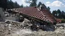 Salah satu warga pinggiran kota Roma, Stara Zagora, Bulgaria, terduduk di depan tempat tinggalnya yang nyaris rata dengan tanah karena dianggap ilegal, (21/7/2014). (REUTERS/Stoyan Nenov)