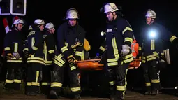 Petugas pemadam kebakaran membawa penumpang yang terluka usai terjadinya tabrakan kereta di Meerbusch, Jerman, (5/12). Dua kereta yang tabrakan adalah kereta ekspres regional dan kereta kargo yang dioperasikan oleh DB Cargo. (Arnulf Stoffel / dpa via AP)