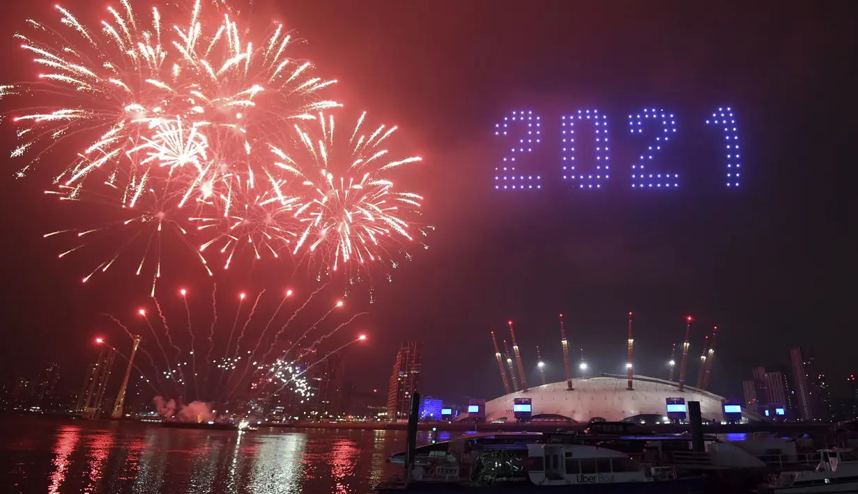 Kembang api dan drone menerangi langit malam di atas London saat mereka membentuk tampilan cahaya saat pertunjukan kembang api Malam Tahun Baru London yang normal dibatalkan karena pandemi virus corona pada Kamis, 31 Desember 2020. (Victoria Jones / PA via AP)