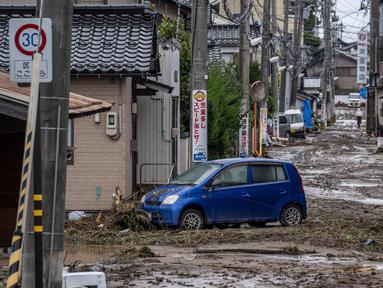 Sebuah mobil yang terdampar terlihat di jalan yang tertutup lumpur setelah hujan lebat di kota Wajima, prefektur Ishikawa, Jepang, pada tanggal 22 September 2024. (Yuichi YAMAZAKI/AFP)