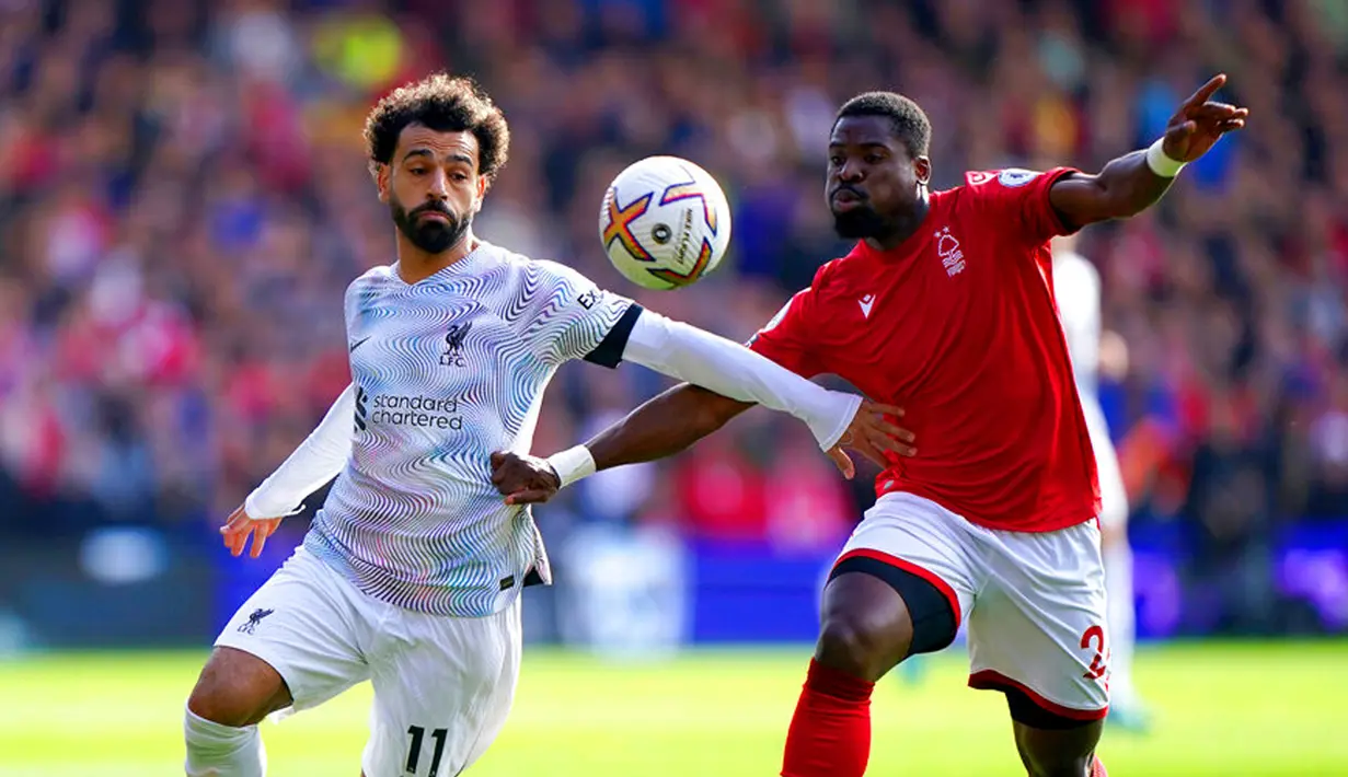 Pemain Liverpool Mohamed Salah (kiri) berebut bola dengan pemain Nottingham Forest Serge Aurier pada pertandingan sepak bola Liga Inggris di City Ground, Nottingham, Inggris, 22 Oktober 2022. Liverpool dikalahkan dengan skor 0-1. (Joe Giddens/PA via AP)