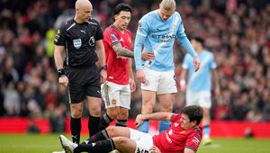 Harry Maguire dari Manchester United, di bagian bawah, tergeletak di lapangan kesakitan sementara wasit Anthony Taylor, Lisandro Martinez dari Manchester United, dan Erling Haaland dari Manchester City bereaksi selama pertandingan Liga Inggris antara Manchester United dan Manchester City di Manchester, Inggris, Sabtu, 17 Januari 2026. (AP Photo/Dave Thompson)
