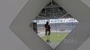 Seorang pekerja menggunakan perlengkapan panjat dinding untuk mengecat rangka besi Stadion Utama Gelora Bung Karno di Senayan, Jakarta, Selasa (23/5/2017).  (Bola.com/Nicklas Hanoatubun)