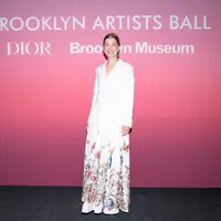 Rosamund Pike mengenakan jaket bordir wol putih Dior Cruise 2024 dengan gaun taffeta sutra putih. Dia juga memakai sepatu Dior. [Dior]