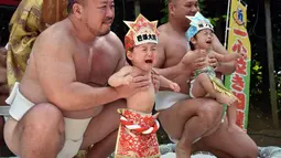 Bayi-bayi tersebut berpartisipasi dalam ritual tradisional tahunan, sebagai doa agar mereka bisa tumbuh sehat seperti para pesumo, Jepang, (21/9/14). (AFP PHOTO/ Yoshikazu TSUNO)