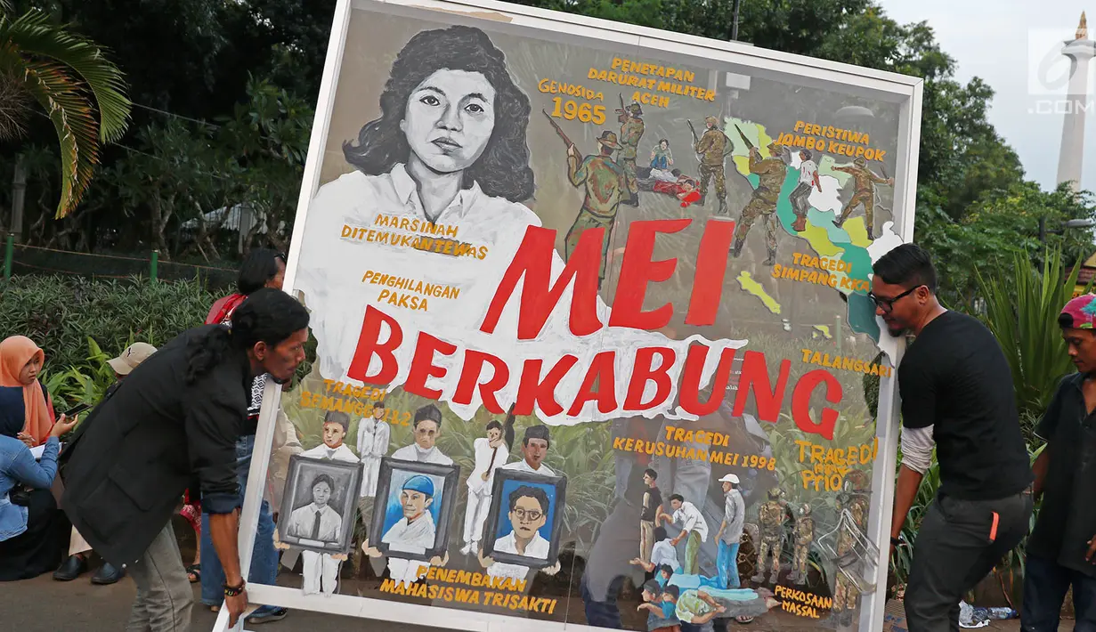 Peserta aksi dari JSKK memajang mural saat menggelar aksi kamisan ke-493 di depan Istana Negara, Jakarta, Kamis (18/5). Aksi tersebut untuk mengingatkan Presiden Jokowi atas banyaknya kasus pelanggaran HAM berat masa lalu. (Liputan6.com/Immanuel Antonius)
