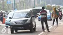 Joki 3 in 1 menawarkan jasa tumpangan kepada kendaraan roda empat di Senayan, Jakarta, Selasa (29/3). Gubernur DKI Jakarta Ahok berencana menghapus kebijakan 3 in 1 di jalan-jalan protokol. (Liputan6.com/Immanuel Antonius)