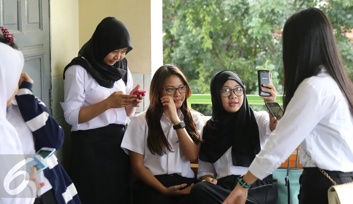 Titania Aurelie Hermansyah (Aurel) berselfie bersama peserta usai ujian Paket C, Jakarta, Selasa (5/4). Aurel  ikut ujian paket C karena tidak menempuh pendidikan formal, melainkan homeschooling. (Liputan6.com/Herman Zakharia) 