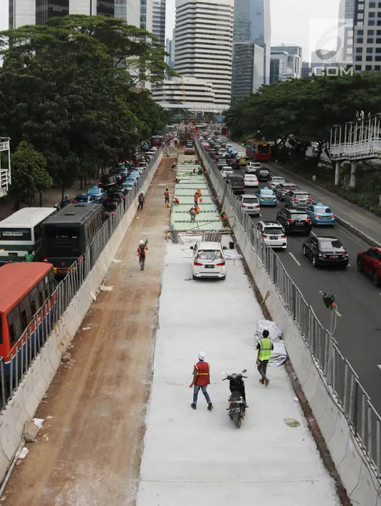 Pekerja menggarap penataan jalan dan trotoar di Jalan Sudirman, Jakarta, Selasa (17/4). Revitalisasi jalan dan trotoar tersebut sebagai persiapan Asian Games 2018 yang akan berlangsung di Jakarta pada Agustus 2018 mendatang. (Liputan6.com/Arya Manggala)