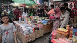 Sejumlah pedagang menjajakan kembang api dagangannya di Pasar Asemka, Jakarta, Selasa (28/12/2021). Menjelang perayaan Tahun Baru, para pedagang musiman menjual petasan dan kembang api di bahu jalan serta kolong jembatan kawasan Pasar Pagi Asemka. (Liputan6.com/Faizal Fanani)