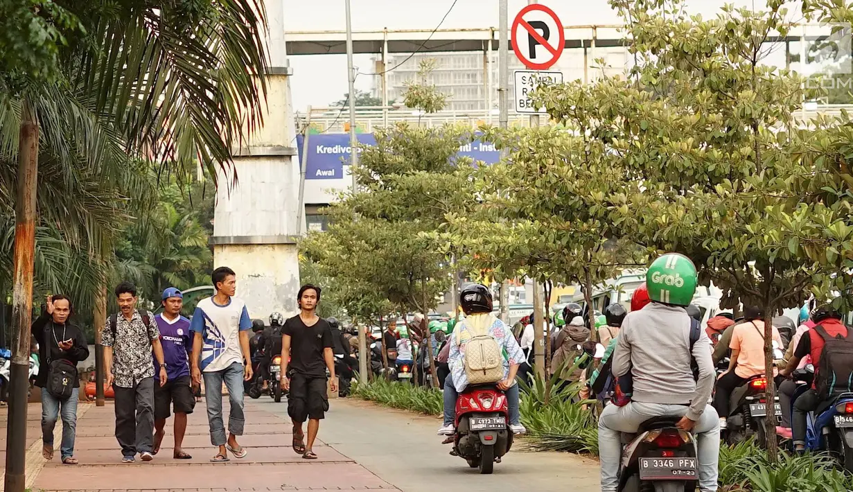 Pengendara sepeda motor melintasi trotoar di kawasan Menteng Pulo, Jakarta, Selasa (14/5/2019). Kemacetan yang semakin parah di Ibu Kota menyebabkan para pemotor nekat menerobos trotoar dan merampas hak pejalan kaki. (Liputan6.com/Immanuel Antonius)
