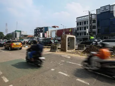 Pengendara melintas di dekat proyek pembangunan saluran air atau drainase di Jalan KH Abdullah Syafei, Jakarta, Selasa (18/7/2023). (Liputan6.com/Faizal Fanani)