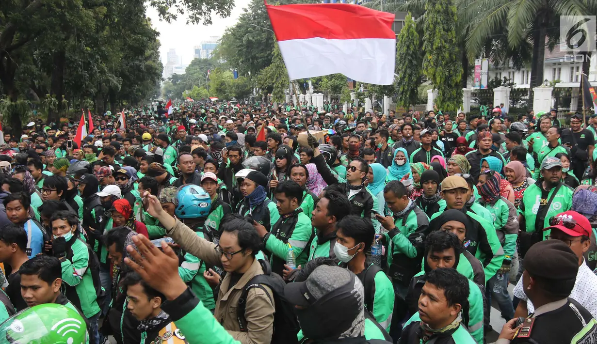 Ribuan pengemudi ojek online melakukan aksi di seberang Istana Merdeka, Jakarta, Selasa (27/3). Dalam aksinya mereka menuntut pemerintah melakukan penetapan tarif standar dengan nilai yang wajar. (Liputan6.com/Arya Manggala)