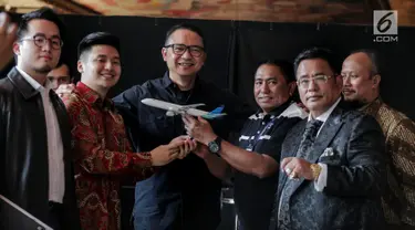 Dirut Garuda Indonesia I Gusti Ngurah Askhara Danadiputra (tiga kiri) bersama youtuber Rius Vernandes (kedua kiri) dan Ketua Harian Serikat Karyawan Garuda Indonesia Tomy Tampati (tiga kanan) foto bersama usai berdamai di Jakarta, Jumat (19/7/2019). (Liputan6.com/Faizal Fanani)