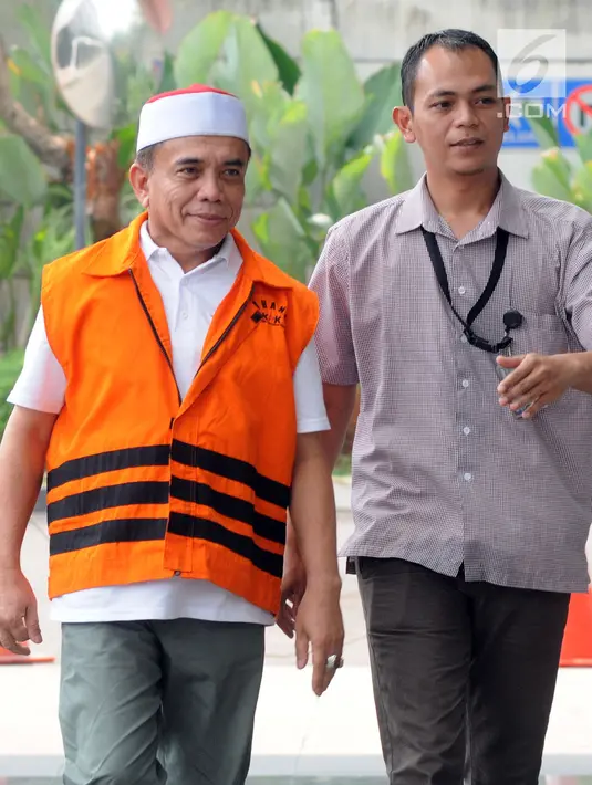 Gubernur Aceh Irwandi Yusuf dikawal petugas berjalan saat tiba di gedung KPK, Jakarta, Rabu (25/7). Irwandi Yusuf diperiksa sebagai tersangka terkait dugaan menerima suap dana Otonomi Khusus (Otsus) Provinsi Aceh tahun 2018. (Merdeka.com/Dwi Narwoko)