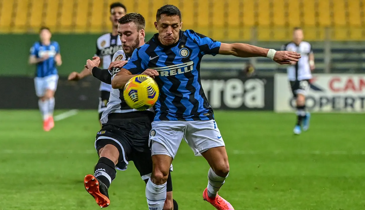 Penyerang Inter Milan, Alexis Sanchez (kanan) menantang bek Parma, Mattia Bani pada pekan ke-25 Serie A 2020/2021, di Stadion Ennio Tardini, Jumat (5/3/2021) dini hari WIB. Dua gol Alexis Sanchez memastikan skor akhir Parma vs Inter Milan menjadi 1-2. (MIGUEL MEDINA / AFP)