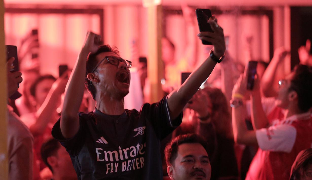 Selebrasi komunitas Arsenal Indonesia saat tim kesayangannya menjebol gawang Liverpool dalam acara Roaring Night pertandingan Premier League 2023/2024 antara Liverpool melawan Arsenal yang berlangsung di Pitch 98, Kemang, Jakarta, Minggu (24/12/2023) dini hari. (Bola.com/Ikhwan Yanuar)