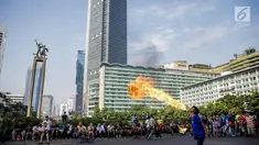 Atraksi menyembur api dengan menggunakan minyak tanah di area Car Free Day kawasan MH Thamrin, Jakarta, Minggu (4/6). Pria yang tergabung dalam kelompok seniman Kuda Lumping itu melakukan aksi berbahaya untuk mencari nafkah. (Liputan6.com/Faizal Fanani)