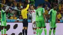 Gelandang Iran, Andranik Teymourian (tengah) harus menerima kartu kuning akibat bermain kasar saat berlaga melawan Nigeria di babak penyisihan Piala Dunia Grup F, Baixada Arena, Brasil, (17/6/2014). (AFP PHOTO/Behrouz Mehri) 