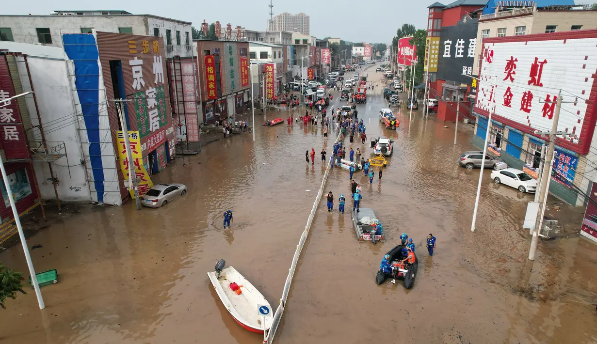Sementara foto-foto lainnya menunjukkan lahan pertanian di daerah sekitarnya terendam seluruhnya dan air banjir membentang bermil-mil jauhnya. (Jade Gao / AFP)
