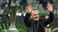 Pelatih Chelsea, Enzo Maresca, melambaikan tangan kepada suporter di dekat trofi UEFA Conference League yang diraih tim asuhannya setelah mengalahkan Real Betis dengan skor 4-1 di laga final yang berlangsung pada Kamis (29/5/2025) dini hari WIB. (AP Photo/Denes Erdos)