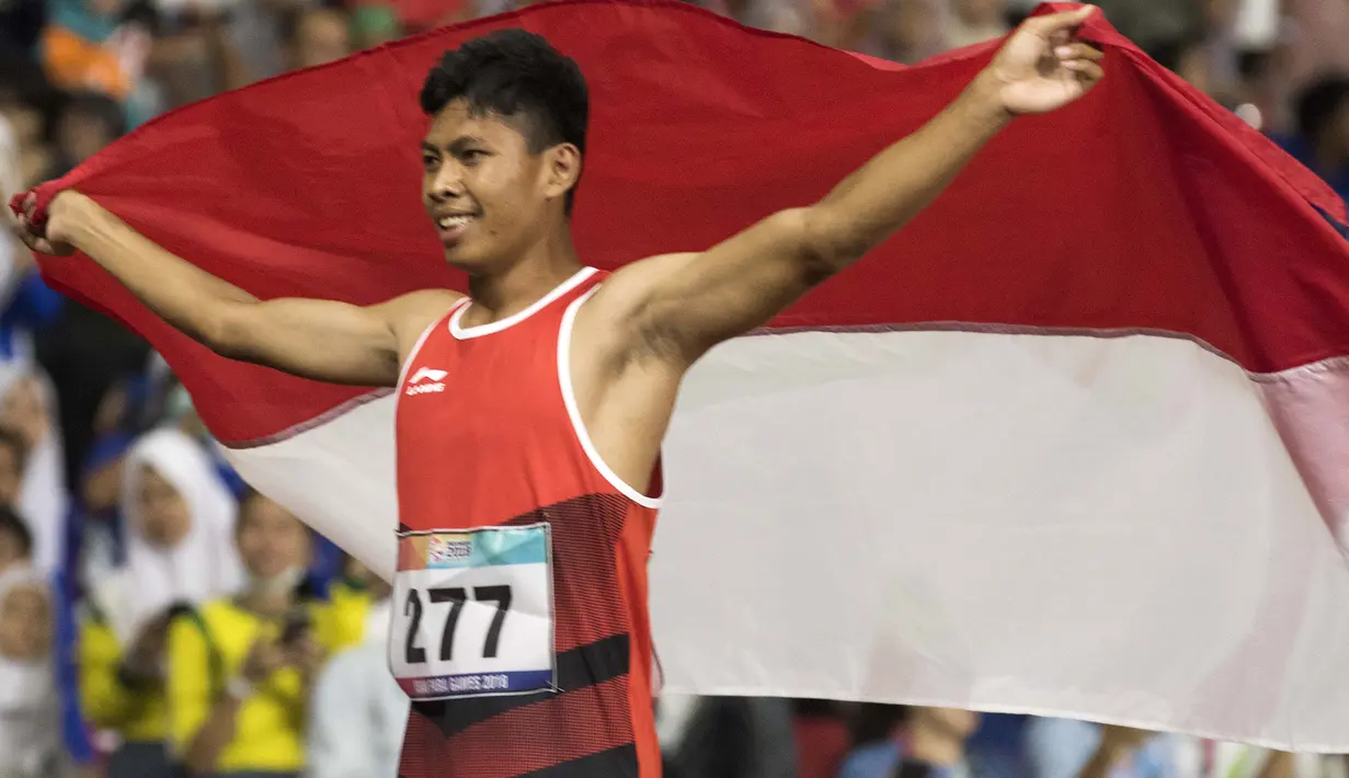 Purnomo Sapto Yogo pelari Indonesia meraih medali emas di nomor 100 meter putra klasifikasi T37 pada Asian Para Games 2018, di Stadion Utama Gelora Bung Karno Jakarta, Selasa (9/10/2018).  (Bola.com/Peksi Cahyo)