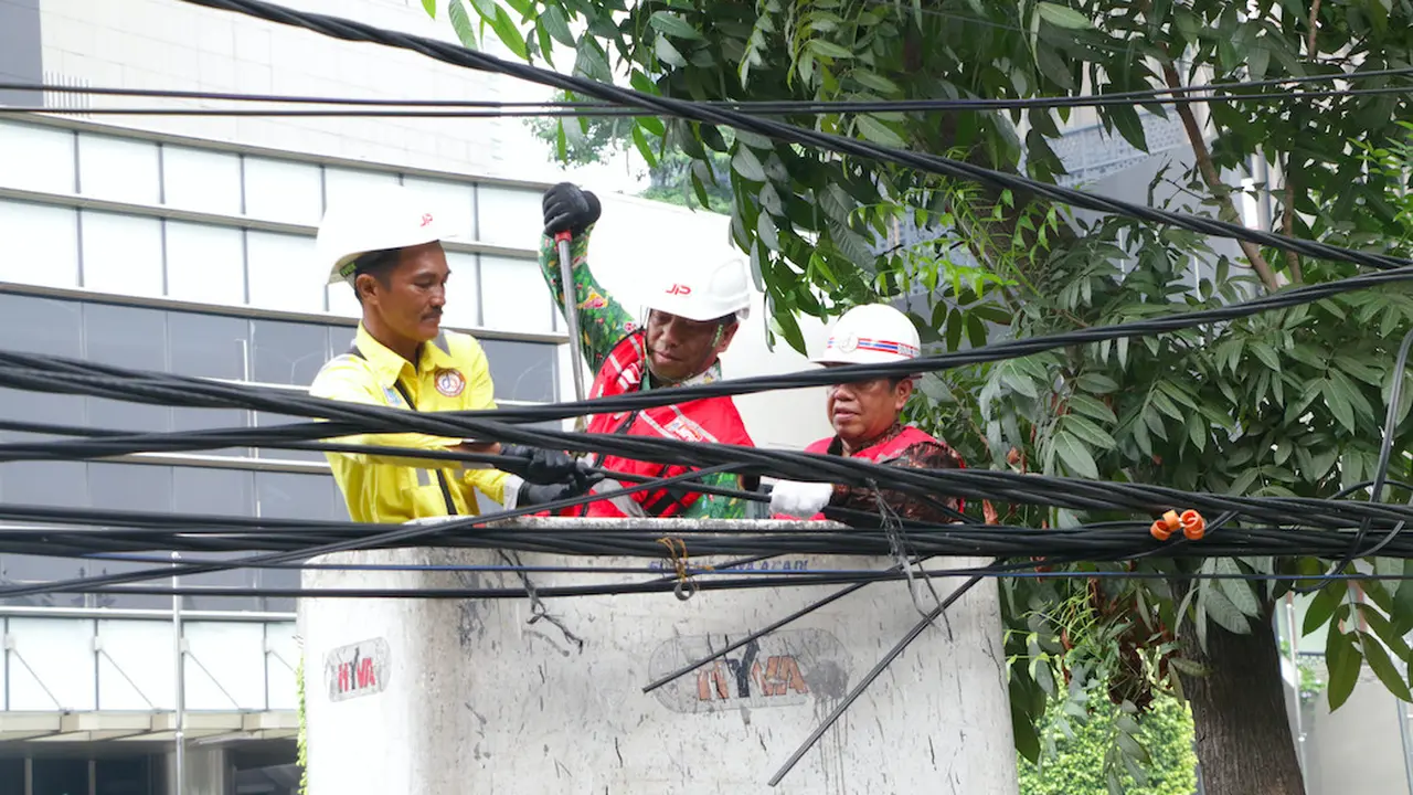 Petugas dari Dinas Bina Marga didampingi JIP memotong kabel fiber optik yang semrawut di kawasan Jalan Senopati, Jakarta, Kamis (24/8/2023). (Liputan6.com/Faizal Fanani)