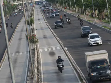 Pengendara sepeda motor menerobos jalur Transjakarta di Jalan Gunung Sahari, Jakarta, Rabu (13/7). Tidak adanya palang pintu membuat sejumlah oknum pemotor nekat menerobos jalur tersebut. (Liputan6.com/Immanuel Antonius)