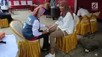 Petugas medis Puskesmas memeriksa tekanan darah petugas Kelompok Penyelenggara Pemungutan Suara (KPPS) yang bertugas saat pemungutan suara ulang di TPS 49 Rengas, Ciputat Timur, Tangsel, Rabu (24/4). Pemeriksaan untuk antisipasi menurunnya kesehatan fisik akibat kelelahan. (merdeka.com/Arie Basuki)