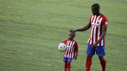 Jackson Martinez menggandeng anaknya Josue saat diperkenalkan sebagai pemain baru Atletico Madrid di Stadion Vicente Calderon, Madrid, Minggu (26/7/2015).(Reuters/Susana Vera)