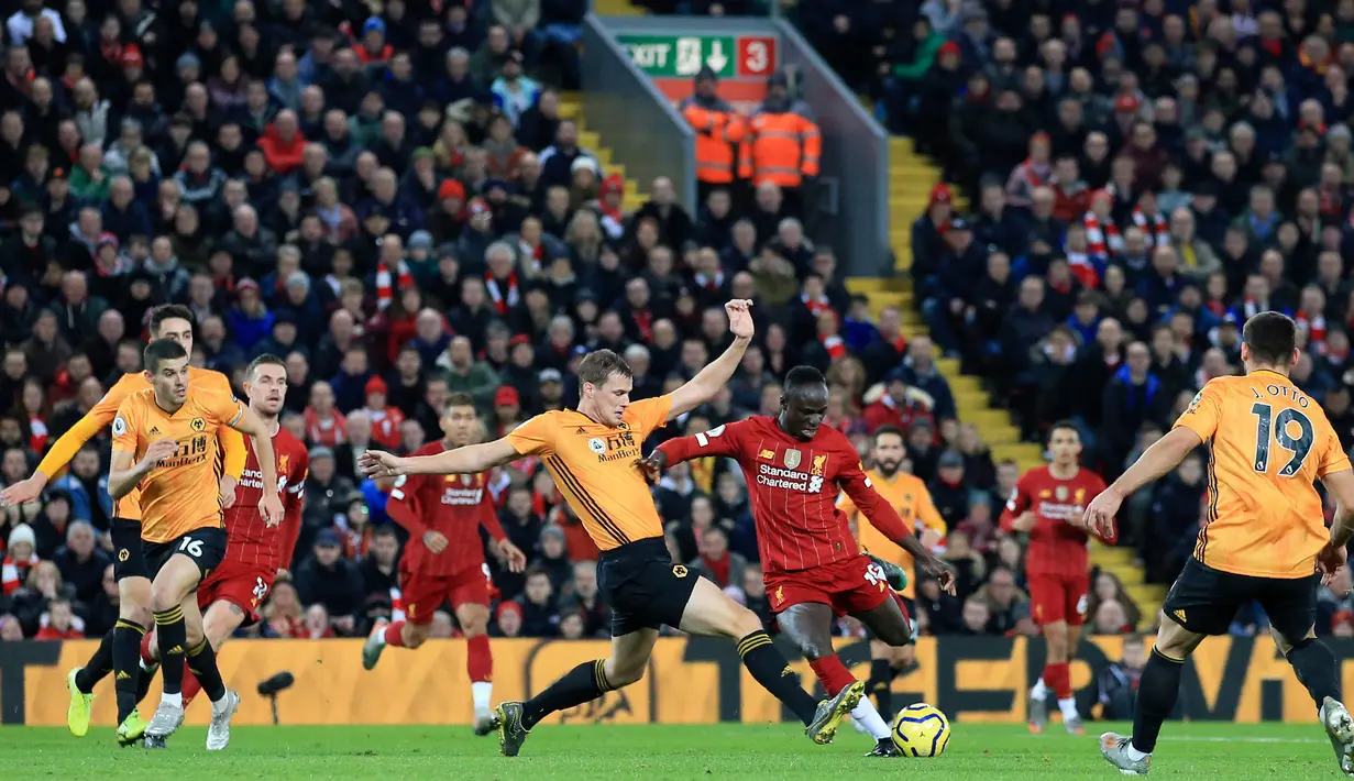 Striker Liverpool, Sadio Mane melakukan tendangan ke arah gawang Wolvehampton Wanderers pada pekan ke-20 Liga Inggris 2019-2020 di Anfield, Minggu (29/12/2019). Liverpool menang lewat gol tunggal Sadio Mane di menit ke-42, yang sempat dicek VAR lebih dulu. (AP/Jon Super)