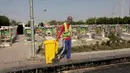 Seorang pekerja menarik tempat sampah di pemakaman Wadi al-Salam, di Najaf, selatan Baghdad, Irak, 5 Agustus 2016. Jumlah kuburan terus bertambah setiap tahunnya, sejak perang Irak 2004 silam. (REUTERS/Alaa Al-Marjani)