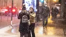Seorang perempuan merekam temannya di tengah badai musim dingin di pusat kota Chicago, AS pada 29 Desember 2020. Para komuter pagi di Chicago menghadapi jalanan yang licin dan lalu lintas yang lambat pada Rabu (30/12) ketika badai musim dingin besar pertama melanda kota itu. (Xinhua/Joel Lerner)