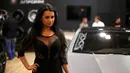 Seorang SPG berpose di depan mobil saat pameran Essen Motor Show di Essen, Jerman, (27/11). Essen Motor Show berlangsung dari tanggal 28 November sampai 6 Desember. (REUTERS/Ina Fassbender)