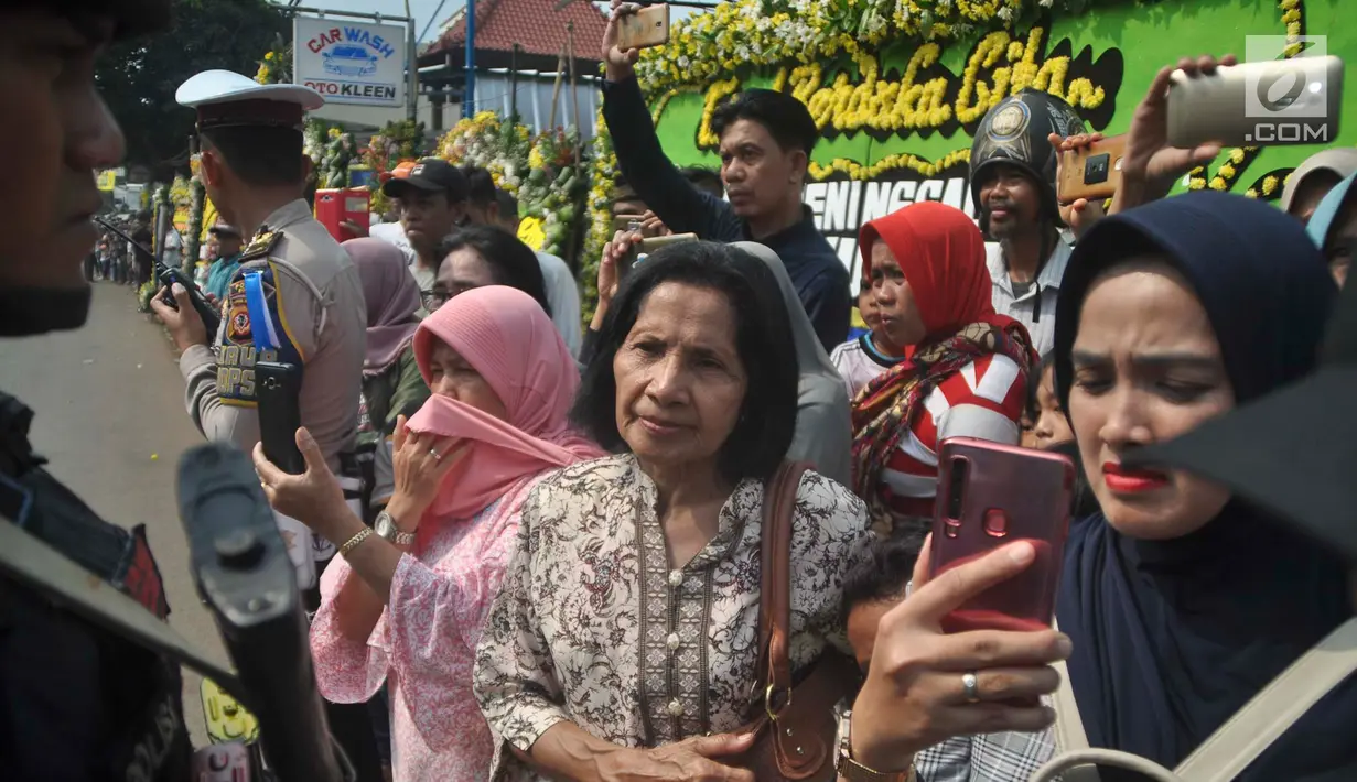 Warga sekitar Puri Cikeas bersiap menyambut iring-iringan kepergian jenazah Ani Yudhoyono menuju TMP Kalibata, Bogor, Jawa Barat, Minggu (2/6/2019). Ani Yudhoyono dimakamkan di TMP Kalibata. (Liputan6.com/Immanuel Antonius)