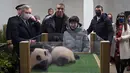Kylian Mbappe dan Zhang Jiaqi tampak tersenyum ketika berada di depan kotak yang diisi Yuandudu dan Huanlili. Dua bayi panda tersebut tampak meringkuk dan saling memeluk satu sama lain. (AFP/Guillaume Souvant)