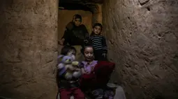 Sejumlah bocah saat berada di ruang bawah tanah Abu Omar di Douma, Damaskus, Suriah, (30/10). Ruangan ini menjadi tempat berlindung Omar dan keluarganya dari peperangan yang terjadi. (AFP PHOTO/Sameer Al-Doumy)