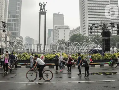 Warga beraktivitas saat car free day (CFD) di kawasan Bundaran HI, Jakarta, Minggu (29/12/2019). Kendati tidak seramai saat cerah, warga yang berlari, jalan santai, atau swafoto masih menjadi pemandangan di area CFD usai hujan mengguyur Jakarta. (Liputan6.com/Faizal Fanani)