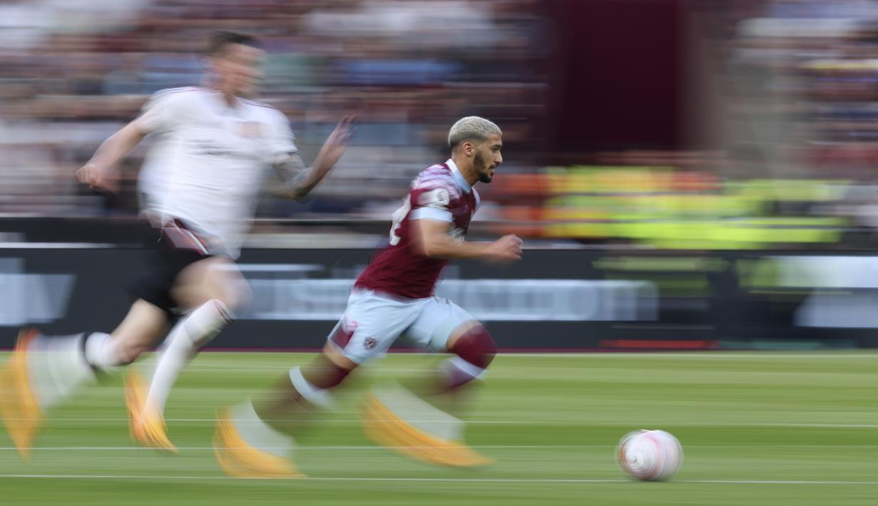 Pemain West Ham United, Said Benrahma (kanan), mengontrol bola dibayangi pemain MU dalam laga pekan ke-35 Premier League 2022/2023 yang berlangsung di London Stadium, Senin (8/5/2023) dini hari. (AP Photo/Ian Walton)