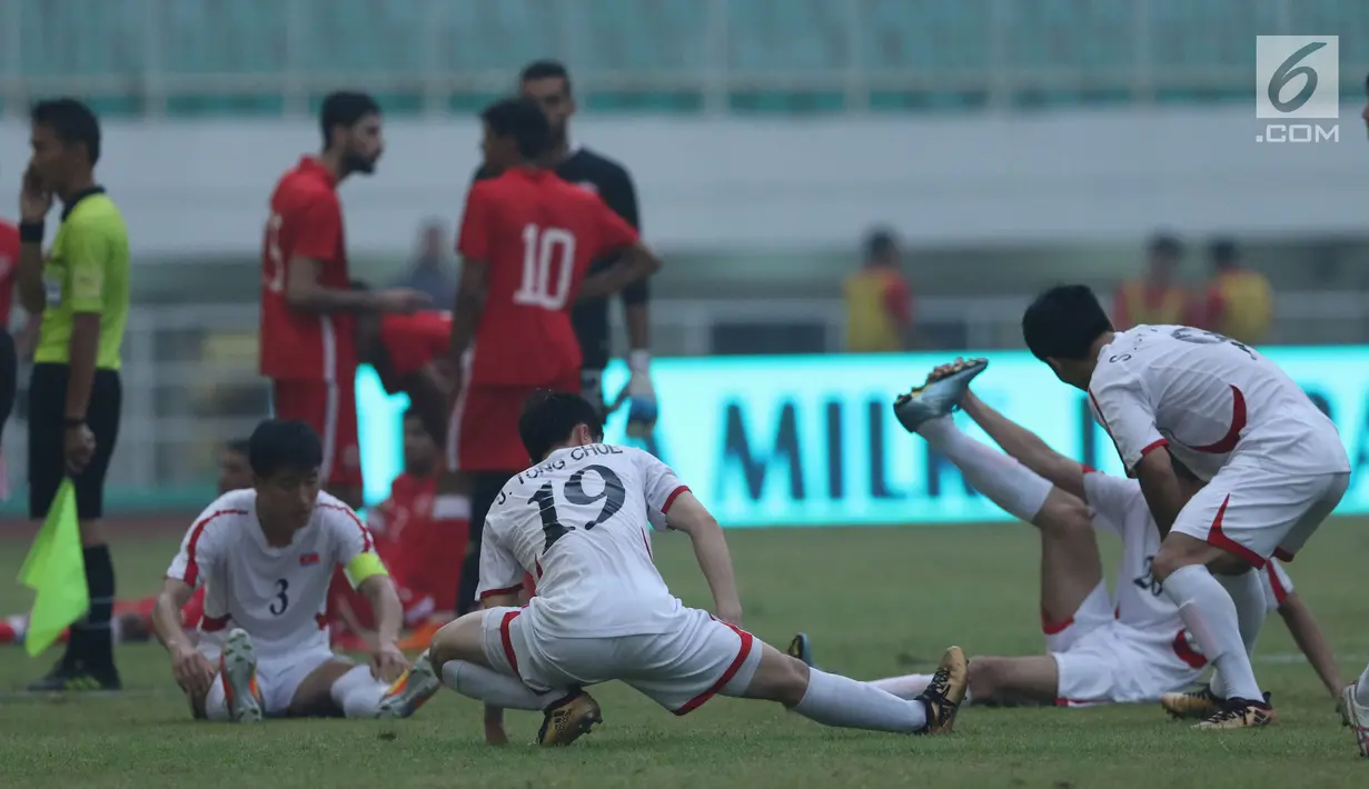 Pemain Korea Utara melakukan peregangan saat laga melawan Bahrain dihentikan sementara akibat lampu mati pada  PSSI Anniversary Cup 2018 di Stadion Pakansari, Kab Bogor, Kamis (3/5). Laga dimenangkan Bahrain 4-1. (Liputan6.com/Helmi Fithriansyah)